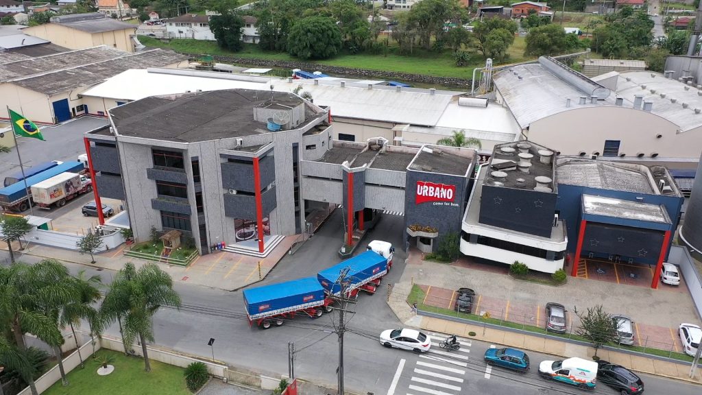 Vista aérea da sede da Urbano Alimentos com caminhões de distribuição