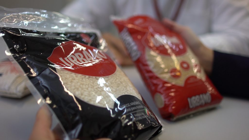 Pacotes de arroz Urbano Alimentos em destaque nas mãos de consumidores